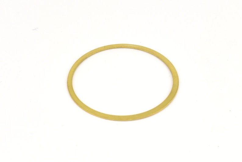 May include: A gold-colored metal washer.
