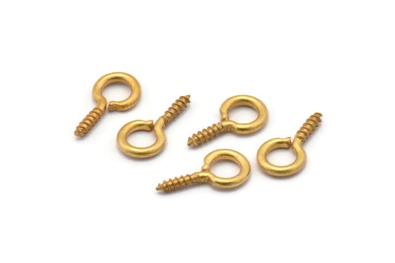 May include: Six gold-toned screw-in eyelet hooks with a small loop at the top. These are commonly used for jewelry making or crafts.