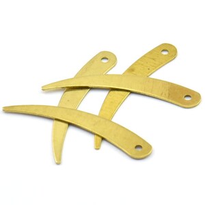 May include: Four brass, curved, metal pieces with holes. The pieces are arranged in a criss-cross pattern.