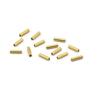 May include: A group of 14 gold-colored metal tubes, scattered on a white surface. The tubes are about 1 inch long and have a smooth, shiny finish.
