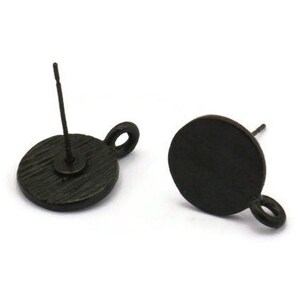 May include: Two black metal earring blanks with a round shape and a small loop on the side. The earring blanks are designed to be used with a variety of charms and pendants.