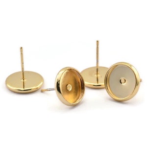 May include: Three gold-toned earring settings with round bezels. The bezels are designed to hold a cabochon stone or other embellishment.