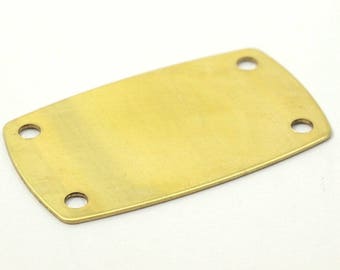 Op de afbeelding: Een blanke messingplaat met vier gaten om aan een oppervlak te bevestigen. De plaat is glad en heeft een licht afgeronde vorm.
