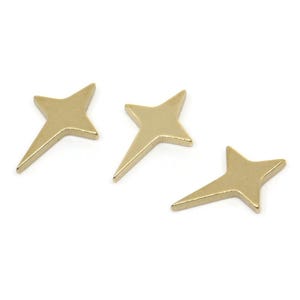 May include: Three gold star-shaped charms with a pointed tip. The charms are small and delicate.