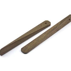 K&ouml;nnte beinhalten: Zwei Holzstift mit einem Loch, das oben durchgebohrt ist. Die Stifte sind braun und haben eine nat&uuml;rliche Holzmaserung.