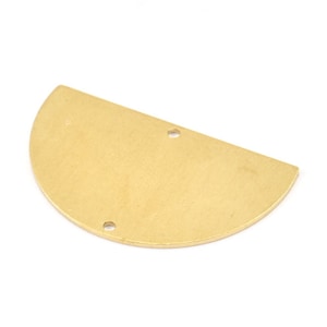 May include: A brass-colored, half-circle metal component with two small holes. The flat surface has a matte finish. This jewelry finding is likely used for earrings, pendants, or other craft projects. The shape is a simple, geometric design.