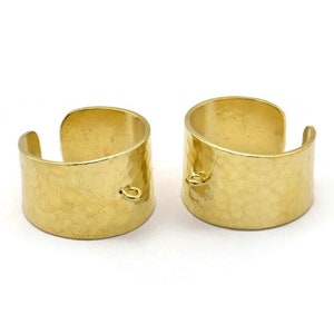 Puede incluir: Dos pendientes de aro de metal martillado dorado con un pequeño bucle en cada uno. Los pendientes están abiertos y listos para ser usados.