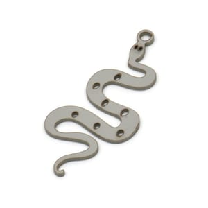 Peut inclure: Un charme en forme de serpent argenté avec une boucle en haut pour l'attacher à un collier ou un bracelet. Le serpent a une surface texturée et est décoré de petits trous.