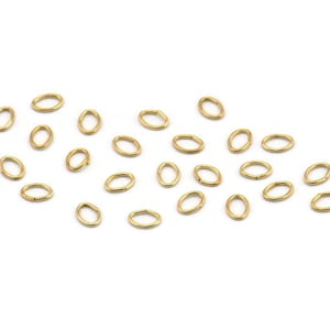 May include: A scattering of gold-toned oval jump rings, ideal for jewelry making or crafting projects.