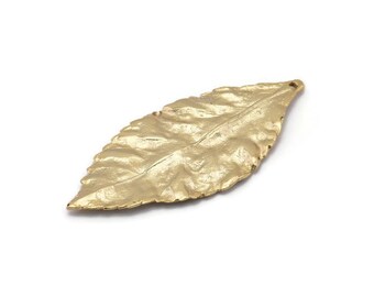 May include: A gold leaf charm with a detailed textured surface. The leaf is slightly curved and has a hole at the top for attaching to jewelry or other crafts.