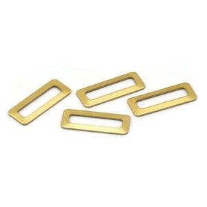 Pode incluir: Quatro anéis retangulares de metal de cor dourada com um furo no centro. Estes anéis são comumente usados para a fabricação de joias ou artesanato.