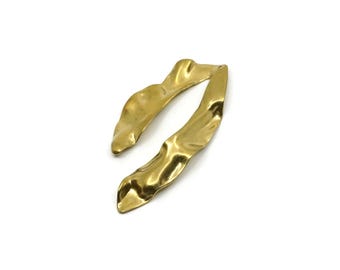 Könnte beinhalten: Ein Paar goldfarbene Metallohrringe mit einer länglichen, organischen und wellenförmigen Silhouette. Die Oberfläche jedes Ohrrings hat ein glattes, reflektierendes Finish mit sanften Kurven und unregelmäßigen, fließenden Kanten.