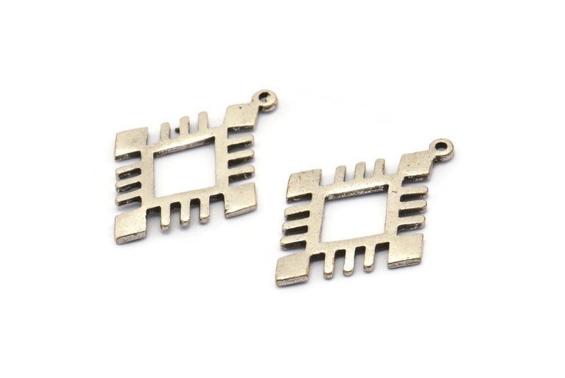 May include: Two silver-toned metal charms in the shape of a square with a geometric design. Each charm has a loop at the top for attaching to a necklace or bracelet.