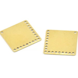 Peut inclure: Deux plaques carrées en métal de couleur dorée avec une bordure décorative de petits cercles. Les plaques sont parfaites pour ajouter vos propres designs ou textes.