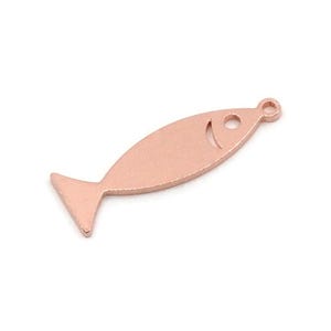 May include: A rose gold fish-shaped charm with a small loop at the top for hanging. The charm has a simple, minimalist design with a curved mouth and a triangular tail fin. The charm is approximately 1 inch long.