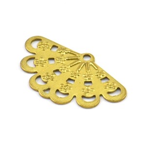 May include: Gold metal fan-shaped charm with a decorative design. The charm has a hole at the top for attaching to jewelry or other crafts.