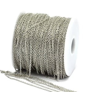 May include: A spool of silver chain, wound tightly and ready to be used for jewelry making or other craft projects.