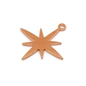 Pode incluir: Um berloque em forma de estrela de cor cobre com oito raios pontiagudos e um pequeno laço na parte superior para prender a joias. O berloque é feito de metal brilhante sobre um fundo branco.