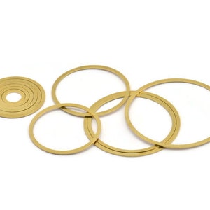 Könnte beinhalten: Ein Satz aus sechs goldfarbenen Metallringen in verschiedenen Größen. Die Ringe sind übereinander gestapelt.