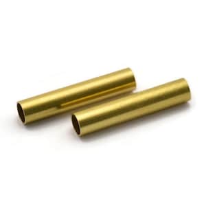 Op de afbeelding: Twee gouden metalen buizen, waarvan er één iets langer is dan de andere, liggen op een wit oppervlak.