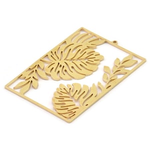 May include: Gold-toned metal pendant featuring a cut-out design of tropical leaves. The pendant is rectangular in shape and has a hole at the top for hanging.