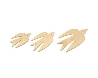 May include: Three gold-colored metal bird charms in varying sizes are arranged on a white background. Each bird has a cutout wing design and a small hole near the head. These charms are suitable for jewelry making or craft projects.