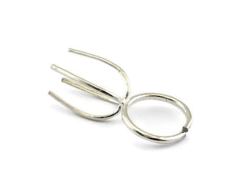 May include: Silver prong setting for a ring, with a round base and three prongs.