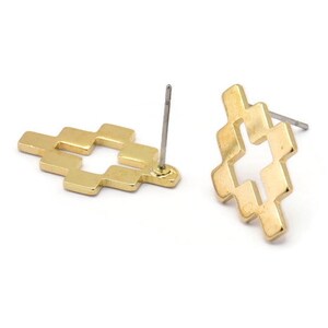 May include: A pair of gold-toned stud earrings with a geometric cross design. The earrings have a post back closure.