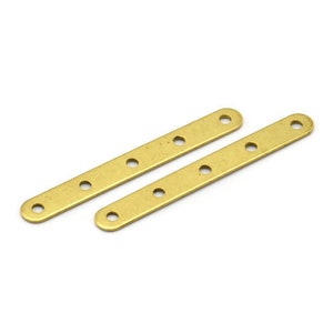 May include: Two gold-colored metal strips with five holes each. The strips are flat and rectangular.