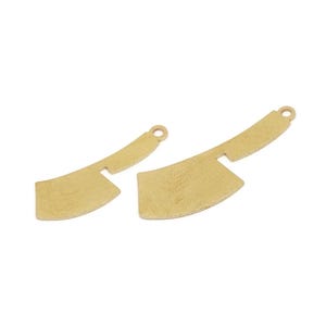 May include: Two gold-colored cleaver charms. The charms have a textured surface and a small hole at the top for attaching to jewelry. The cleavers are different sizes, with one slightly larger than the other.