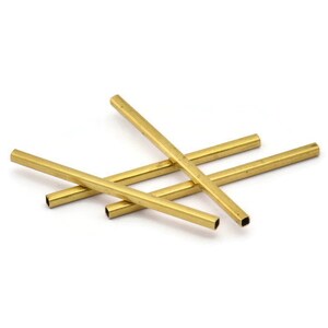 May include: Four gold-coloured metal tubes, each with a square cross-section, are stacked on top of each other.