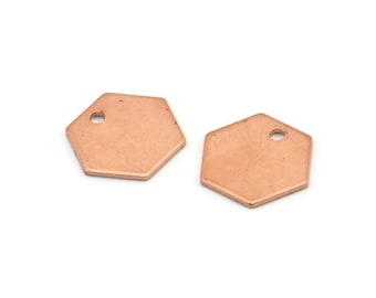 Puede incluir: Dos abalorios hexagonales de metal de color oro rosa con un pequeño agujero en el centro de cada abalorio.