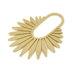 May include: Gold-toned metal earring with a sunburst design. The earring has a large, open circle in the centre.