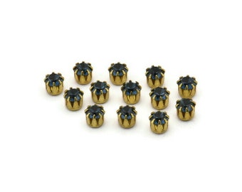 May include: A collection of 15 gold-toned metal settings with dark blue rhinestones. Each setting has a starburst design around the rhinestone.