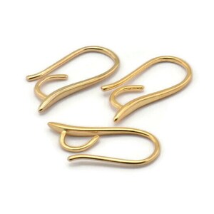 May include: Three gold-toned earring hooks. The hooks are made of metal and have a smooth, curved design.