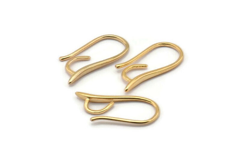 May include: Three gold-toned earring hooks. The hooks are made of metal and have a smooth, curved design.
