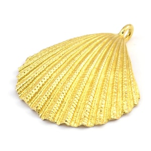 May include: A gold-coloured seashell pendant charm with a detailed textured surface.