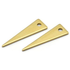 Peut inclure: Deux breloques en métal de forme triangulaire de couleur dorée avec un trou au centre de chacune. Les breloques mesurent environ 2,5 cm de long.