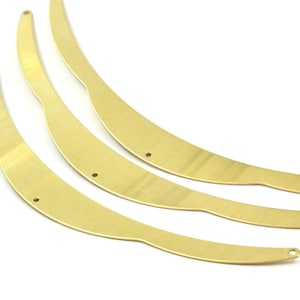 May include: Three gold-colored metal hoops with a slightly curved shape and small holes on each side.
