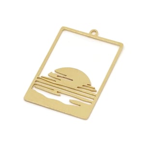 Puede incluir: Colgante rectangular dorado con diseño de puesta de sol. El colgante presenta un recorte de un sol poniéndose sobre el océano, con líneas horizontales que representan el agua y las nubes. Tiene un pequeño lazo en la parte superior.