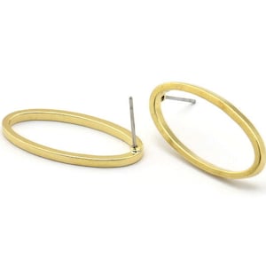 May include: A pair of gold oval-shaped earring blanks with a post and butterfly backing.
