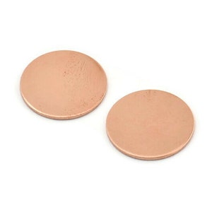 Może przedstawiać: Dwa okrągłe dyski miedziane, każdy z gładką, lekko fakturowaną powierzchnią.