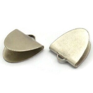 May include: Two silver-toned metal cord end caps with a rounded, slightly pointed shape. Each cap has a small loop on the side.