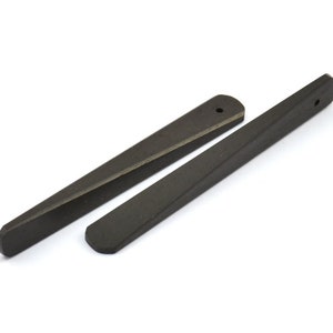 May include: Two black wooden tapered wedges with a hole at the top. The wedges are about 6 inches long.