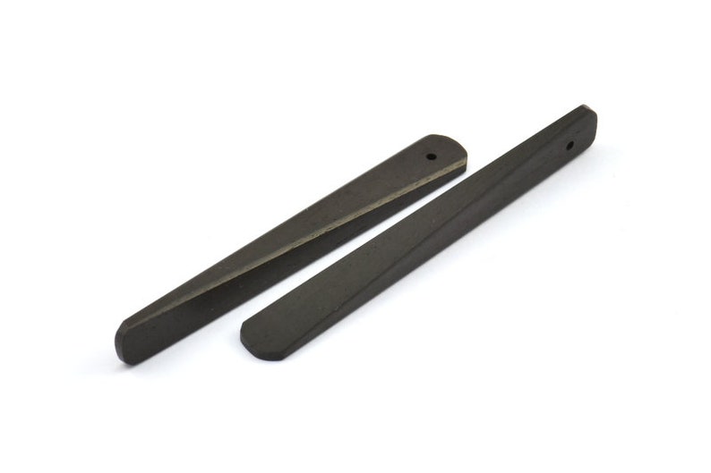 May include: Two black wooden tapered wedges with a hole at the top. The wedges are about 6 inches long.