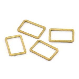 May include: Four gold-coloured metal jump rings, each with a rectangular shape.