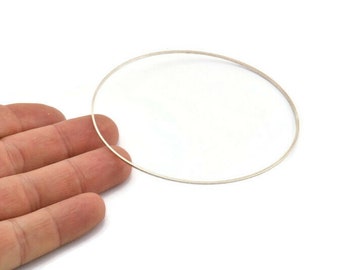 May include: A thin, silver-colored metal ring, shown on a hand.