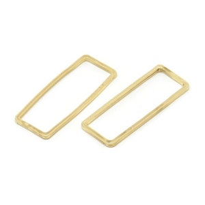 Könnte beinhalten: Zwei rechteckige Metallringe in Goldfarbe. Die Ringe sind offen und haben eine glatte, polierte Oberfläche.