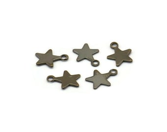 Peut inclure: Cinq breloques en forme d'étoile en métal doré antique avec anneaux de saut. Chaque breloque en forme d'étoile a une forme d'étoile à cinq branches avec un trou au centre.