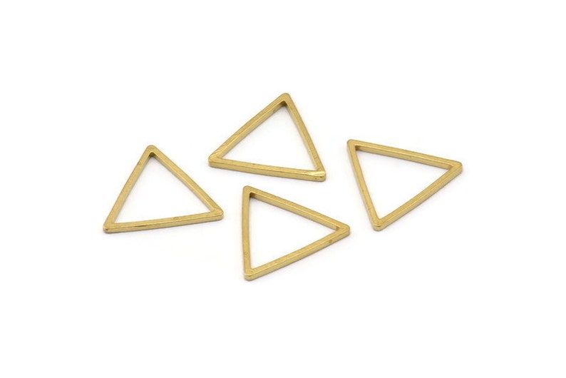 Puede incluir: Cuatro abalorios de metal de forma triangular de color dorado. Los abalorios son huecos y tienen un acabado liso y brillante.